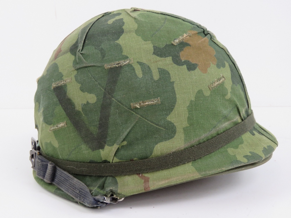 A US Vietnam war helmet with liner and helmet cover.