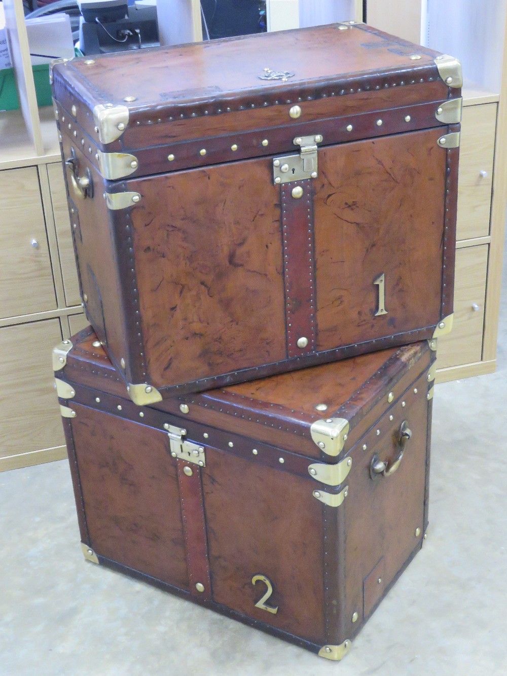 A fine pair of 'Army and Navy' style leather covered military trunks each bearing military insignia