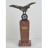 A rouge marble trophy topped with metal eagle and swastika, standing 26.5cm high.