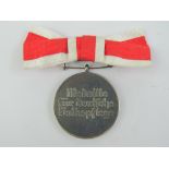 A WWII German Red Cross Medics medal with ribbon.