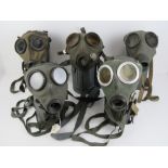 Five German DDR gas masks in tins.