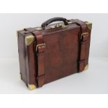 A small leather covered magazine opening to reveal five oak lined compartments within,