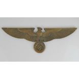 A heavy brass WWII German eagle over swastika plaque, 43cm wingspan.