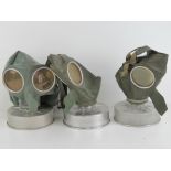 Three WWII German civilian gas masks being for adult, child and baby. Each with filter.