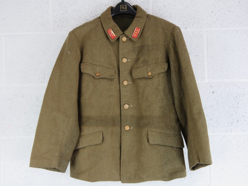 A WWII Japanese army tunic with ranking insignia upon, having packet within inside pocket.