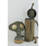 A WWII German gas mask dated 1939, with filter, in carry tin with strap and rare canvas case.