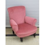 A good blush pink velvet upholstered armchair, raised over short turned legs.