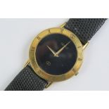 A Gucci wristwatch having yellow metal chapter ring with black dial, strap a/f, with box.