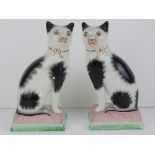 A pair of 20th century opposing seated Staffordshire style cats on cushions, each 18cm high.