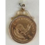 A 22ct gold half Krugerrand, ½ oz fine gold, dated 1980, in a 9ct gold hallmarked pendant mount,