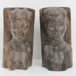 A pair of carved wooden African bookends being male and female busts, each standing 21cm high.