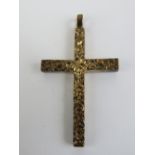 A 9ct gold crucifix having heavy floral engraving, hallmarked 375, 46mm inc bale, 7.9g.