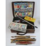 A pigskin leather case containing a quantity of vintage oil paints and painting ephemera,