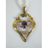 A 9ct gold Edwardian pendant having central oval cut amethyst, floral scroll work frame stamped 9ct,
