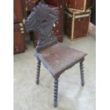A stained oak single hall chair in Carolean revival style having pierced and carved back and