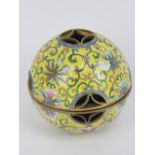 A Chinese Canton enamel on brass hand warmer, having yellow ground with floral decoration upon,