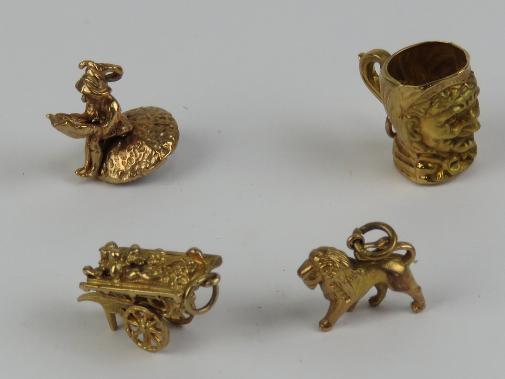 Three 9ct gold charms being tankard, goods cart and lion, each hallmarked.