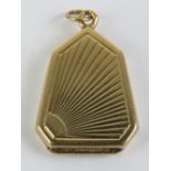 An unusual 9ct gold locket being a heptagon with engraved sunrise design to front, hallmarked 375,