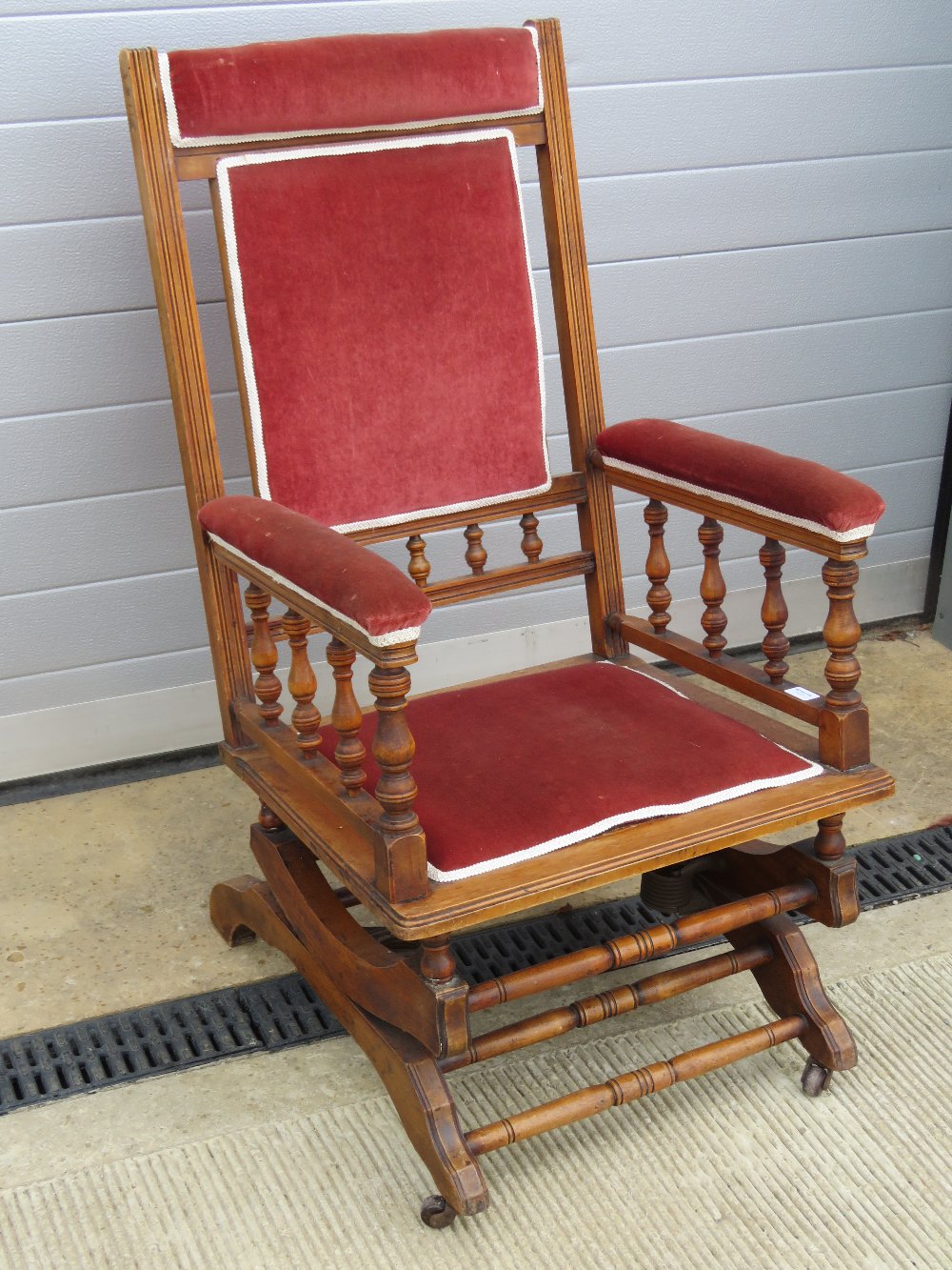 An early 20th century American rocking chair raised over castors.
