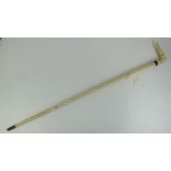 A carved whalebone cane having ladies leg top, 79cm in length.