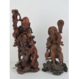 A finely detailed hand carved Japanese deity figurine with staff, 32cm high.