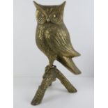 A large life size cast brass owl upon a triform branch, 46cm high.