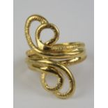 An unusual 18ct gold scrollwork ring, having three rows forming double loop to each side,