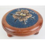 A good contemporary heavy circular mahogany footstool with needlepoint decoration to centre,