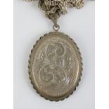 A HM silver locket, having engraved floral design to front and back, on sterling silver chain.
