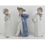 Three Nao figurines each being a young child standing, 25cm high.