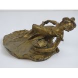 A gilded spelter Art Nouveau inkwell in the form of a recumbent female, 20cm wide,