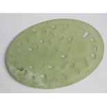 A pierced oval green jade Oriental disc, 8 x 5.5cm.