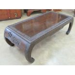 An Oriental hardwood low tea table having single drawer, part carved design upon with inswept legs,