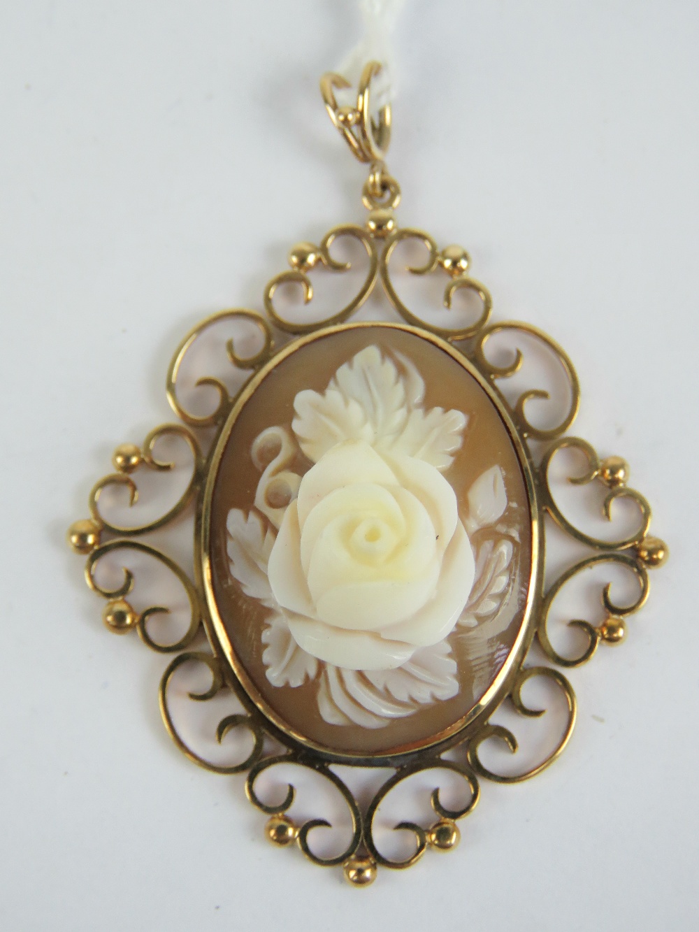 A well carved floral cameo having highly raised rose bud to centre, set in a 9ct gold mount,