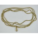 A yellow metal guard chain with locking clasp, no apparent hallmarks, curb links,