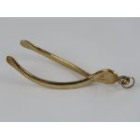 A large 9ct gold pendant in the form of a wishbone, approx 6.
