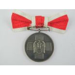 A WWII German Red Cross Medics medal with ribbon.