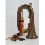 A copper and brass military bugle complete with braided cord and silvered mouthpiece.