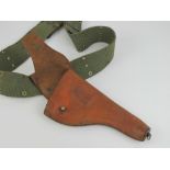 A tan leather Colt 1917 holster with green canvas belt.