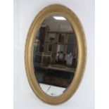 A gilt framed bevelled edge oval wall mi