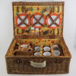 A wicker picnic basket containing plates