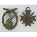 A WWII German crossed swords medal together with a WWII German badge (pin a/f). Two items.