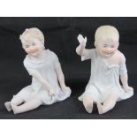A pair of late 19th century Continental bisque seated child figurines, each approx 15cm high.