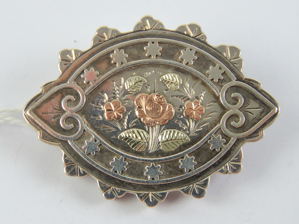 A late Victorian silver mourning brooch having rose metal flowers upon, hallmarked Birmingham 1884,