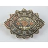 A late Victorian silver mourning brooch having rose metal flowers upon, hallmarked Birmingham 1884,