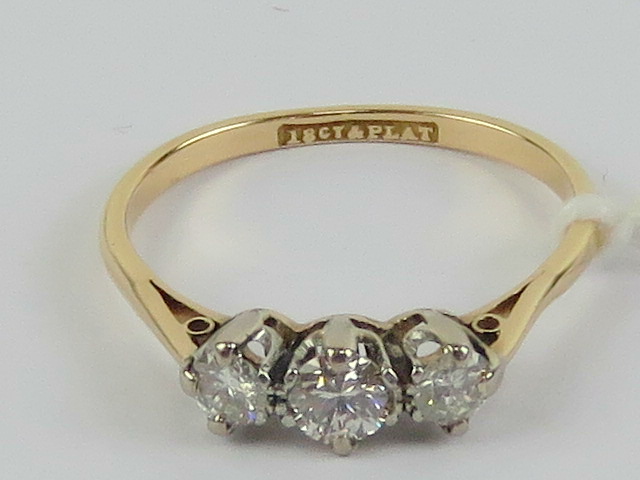 A three stone diamond ring, central stone approx 0.2ct flanked by a pair of 0.