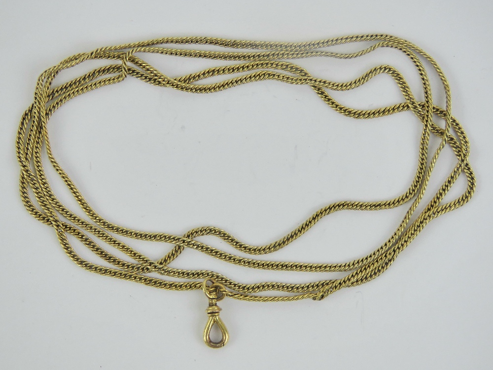 A yellow metal guard chain with locking clasp, no apparent hallmarks, curb links,