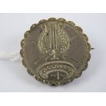 A late Victorian silver mourning brooch having glazed panel to back and applied lyre detail to