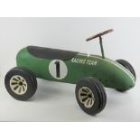 A vintage green painted childs ride on 'Racing Team' car, 71cm in length.