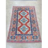 An early 20th century wool and silk rug having geometric design throughout in panels of blue,